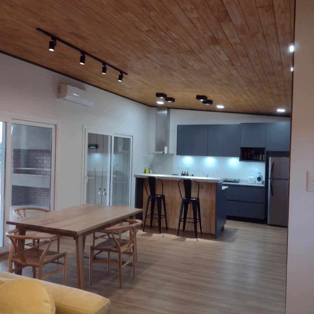 Interior terminado con cocina integrada, isla, comedor de madera y cielorraso de madera